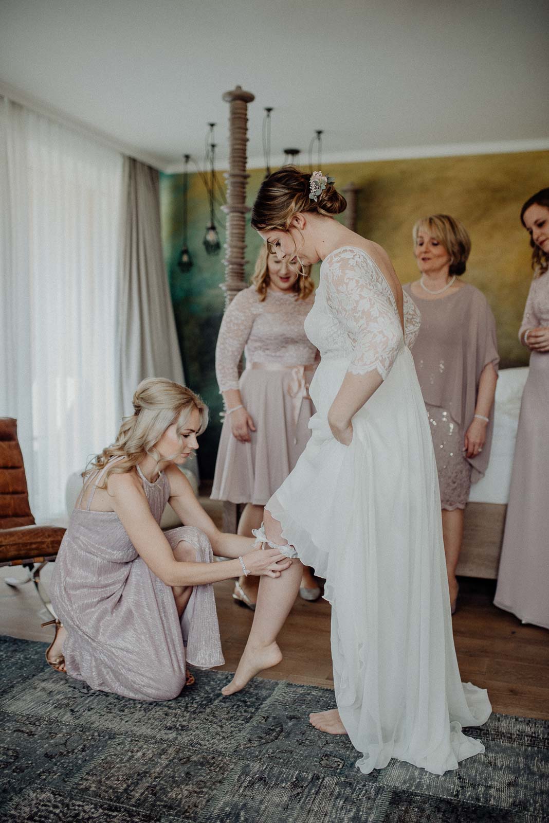 Die Braut erhält Hilfe beim Anziehen Ihres Strumpfbandes