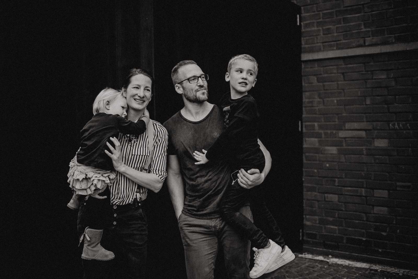 Vierköpfige Familie vor schwarzem Hintergrund bei Familienshooting