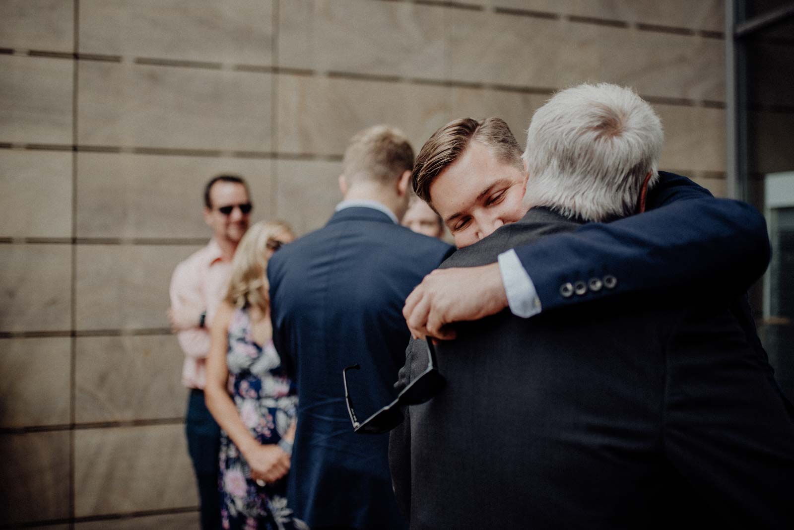 Enkel umarmt Opa bei Hochzeit