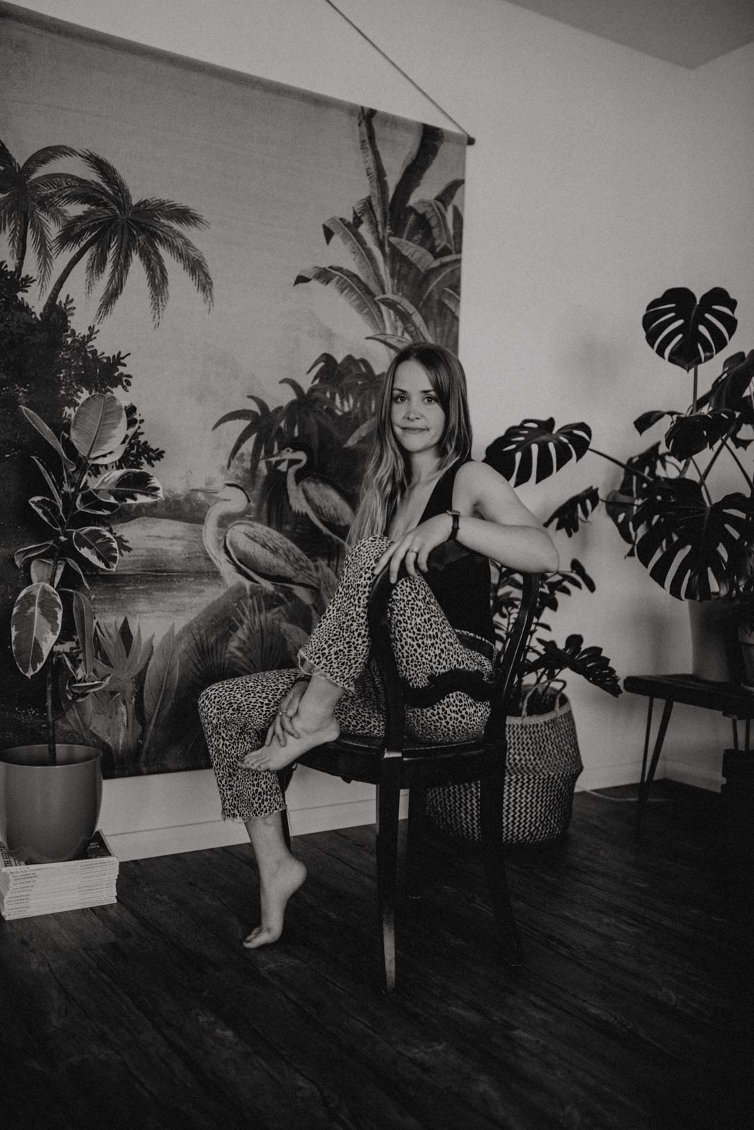 Junge Frau sitzend auf einem Stuhl vor Dschungel Wandbild