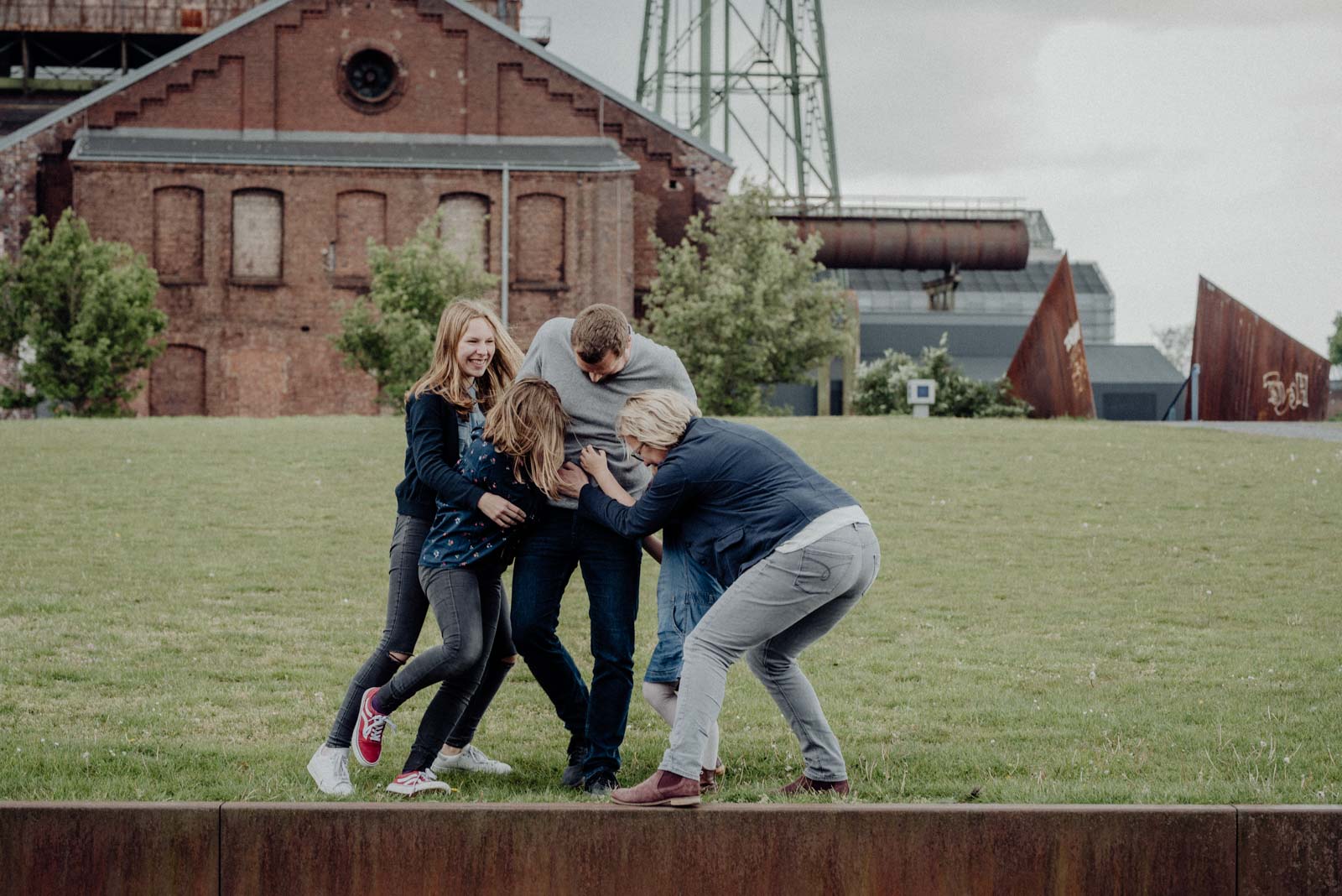 Alle kitzeln Papa beim Familienshooting.