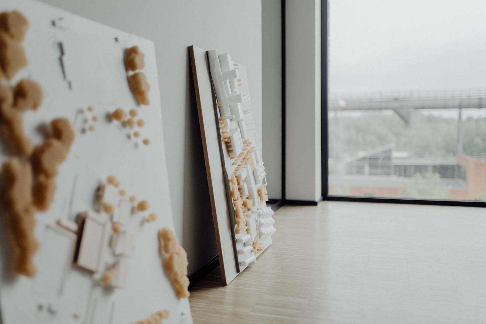 Architekturmodelle lehnen laessig an der Wand im Buero