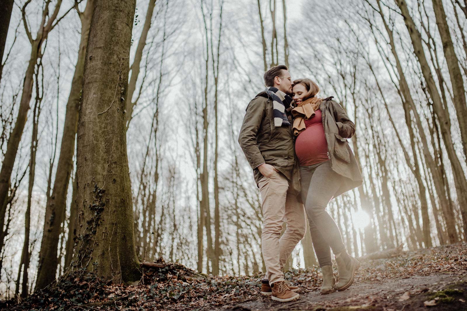 Pärchen im Wald bei Sonnenuntergang mit Babybauch