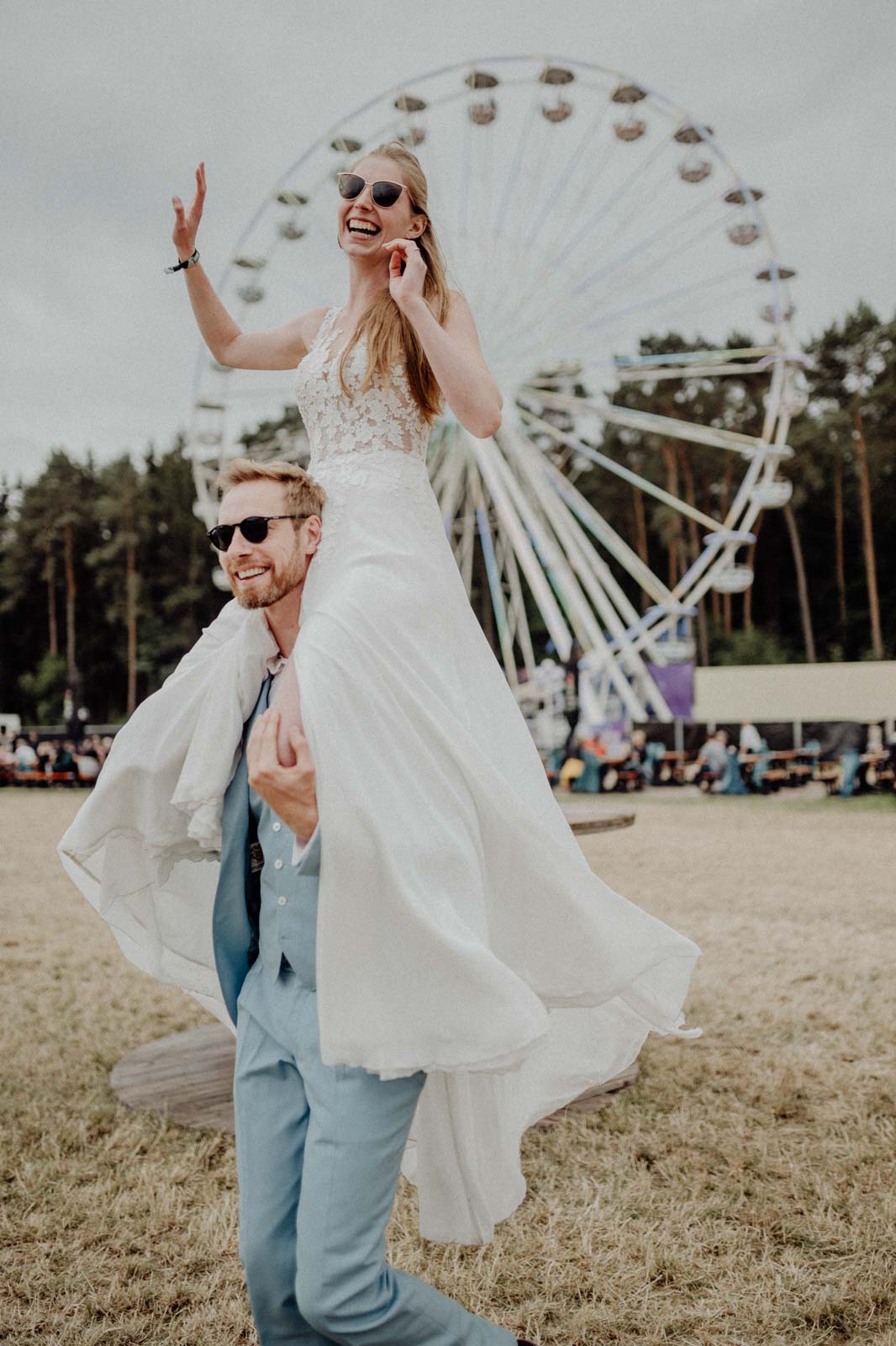 braut lässt sich beim after-wedding-shooting von braeutigam auf seinen schultern tragen